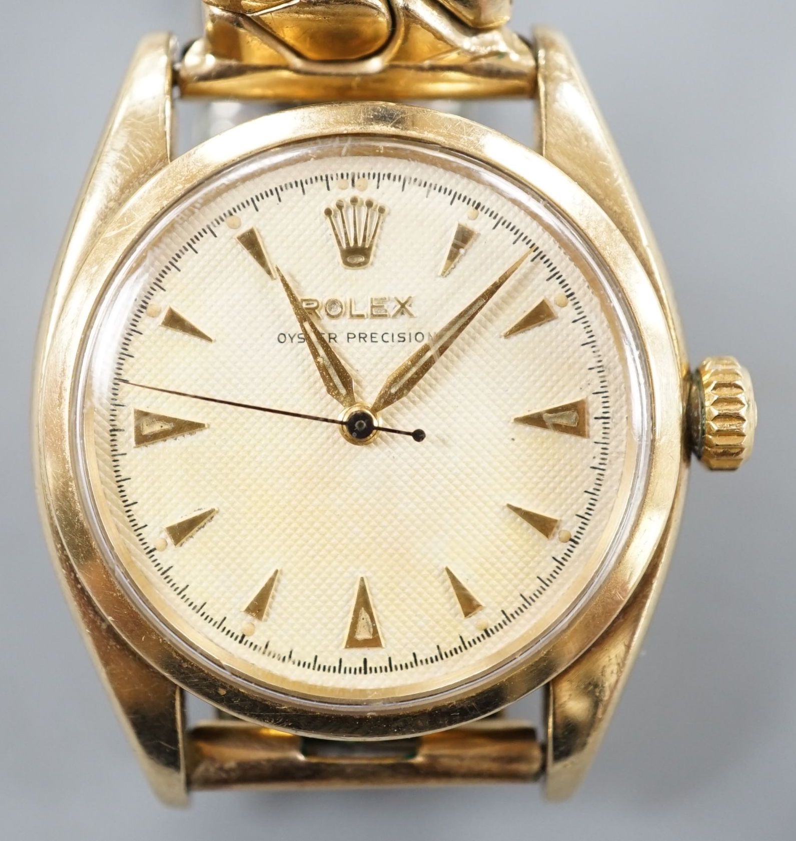 A gentleman's 1950's 9ct gold Rolex Oyster Precision manual wind wrist watch, with honeycomb dial and baton numerals, on associated expanding bracelet, case diameter 35mm, with personalised inscription to case back, no b